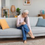 Sad,Caucasian,Elderly,Gray-haired,Woman,In,Glasses,Sit,On,Sofa