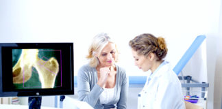 Doctor and patient reviewing x-ray, both female